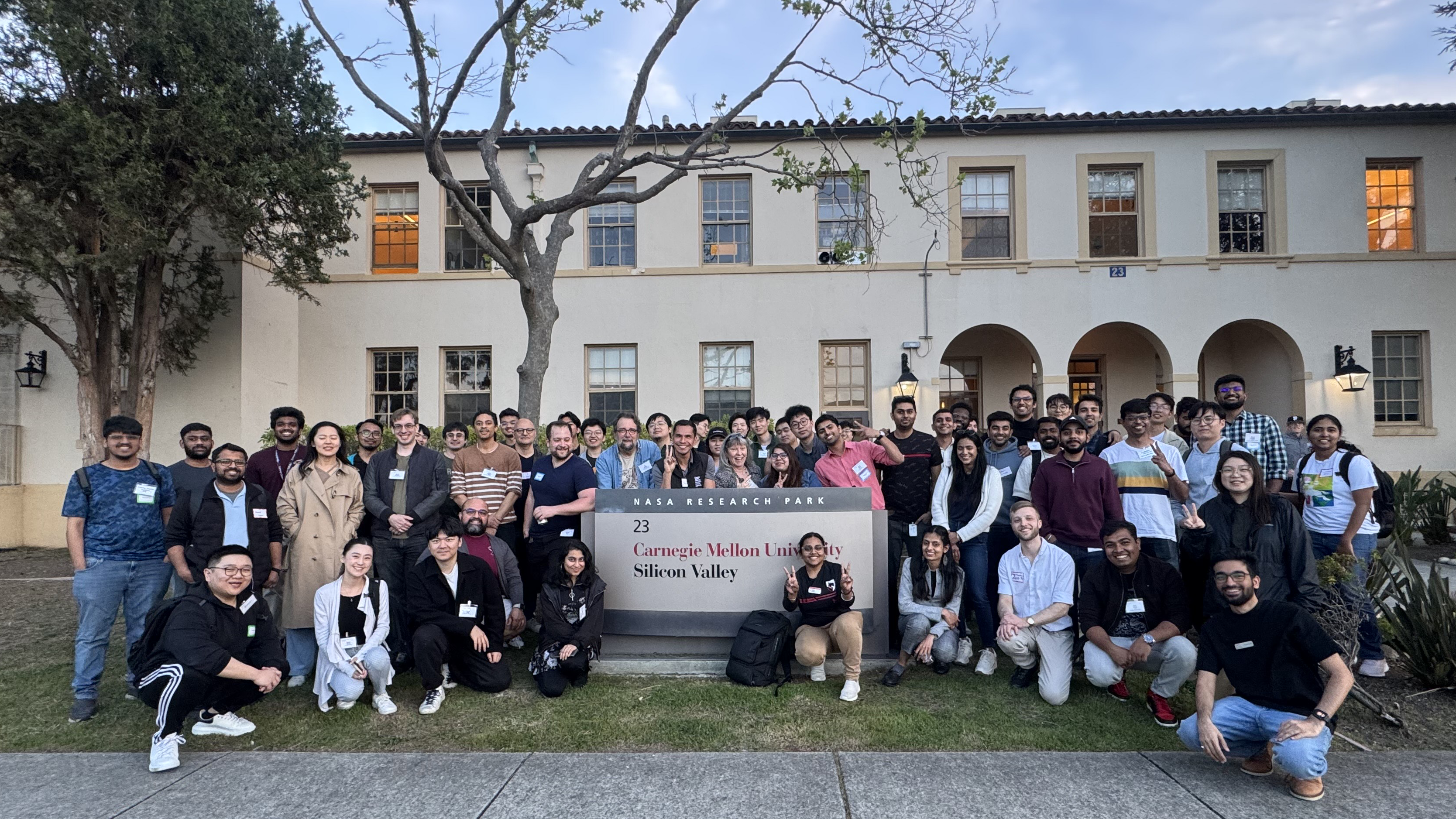 students pose for a photo around CMU SV signage